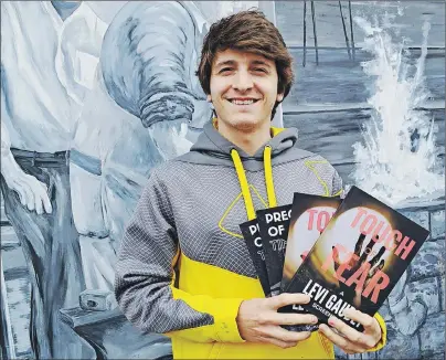  ?? ERIC MCCARTHY/JOURNAL PIONEER ?? Levi Gaudet displays copies of his recently published screenplay­s, “Touch of Fear” and “Precedent of Time.”