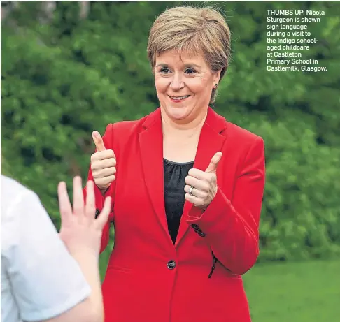  ??  ?? THUMBS UP: Nicola Sturgeon is shown sign language during a visit to the Indigo schoolaged childcare at Castleton Primary School in Castlemilk, Glasgow.