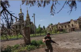  ?? (AP/Bernat Armangue) ?? A Ukrainian soldier patrols a village Thursday near the front line in the Donetsk oblast region in eastern Ukraine. Ukrainian President Volodymyr Zelenskyy, calling for more weapons from the West, said that “as of today, the occupiers control almost 20% of our territory.”