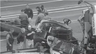  ??  ?? NEW JERSEY. Emergency personnel examine a school bus after it collided with a dump truck, injuring multiple people, on Interstate 80 in Mount Olive, N.J.