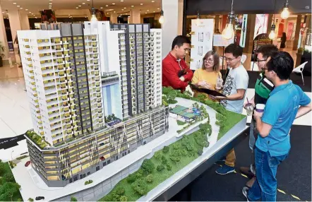  ??  ?? Mah Sing Group sales executive Victor Cheah (left) introducin­g the M Vista project to visitors at StarProper­ty.my Fair in Queensbay Mall in April.