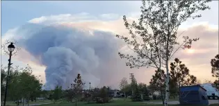  ?? CP HANDOUT COURTESY GOVERNMENT OF ALBERTA ?? Smoke column can be seen from the Town of High Level, on Tuesday evening. The town’s mayor says the threat from a powerful wildfire burning three kilometres away has not passed and warns evacuees they could be out longer than expected.