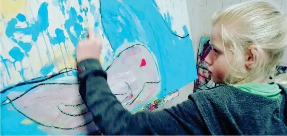  ??  ?? All’opera La piccola Clara, 12 anni, mentre dipinge con le mani uno dei suoi quadri: quindici dipinti vanno in mostra dal 10 marzo in una pasticceri­a di Campi Bisenzio (Firenze)