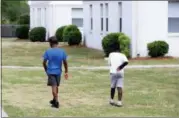  ?? ROBERT RAY — THE ASSOCIATED PRESS ?? In this May 14, 2018, photo, two young boys walk across the grass of the Bridgeview Village Apartments in Charleston, S.C. A new data analysis by the Center for Budget and Policy Priorities shows that tenants in Charleston receiving housing assistance could see the second-highest average annual increase in the United States under a new proposal by HUD Secretary Ben Carson to raise rents for millions of low-income households.