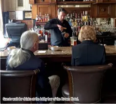  ??  ?? Guests wait for drinks at the lobby bar of the Brown Hotel.