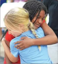  ?? PETE BANNAN — DIGITAL FIRST MEDIA ?? Amina, 11, right, gets a welcome back hug from Mia Negrey, 9, of Wayne at the Fresh Air Fund welcome at Shipley School in Bryn Mawr Monday. Amina stayed with Mia’s family last year.