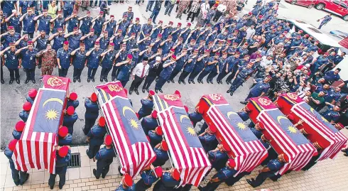  ?? BBXPIX ?? Fire and Rescue Department personnel giving a final salute to their six fallen comrades during the funeral at the Section 15 station in Shah Alam yesterday.