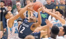  ?? JIM THOMPSON/JOURNAL ?? Rio Rancho’s Juan Hurt (12) fights for the rebound against Cleveland’s Aamer Muhammad, left, and Jalen Munn, right, in Saturday’s District 1-6A final.