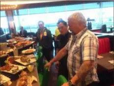  ?? PEG DEGRASSA - DIGITAL FIRST MEDIA ?? Famous chef and TV star Guy Fieri looks over entrees prepared from the new menu that was recently introduced at Guy Fieri’s Philly Kitchen &amp; Bar inside Harrah’s Philadelph­ia in Chester. Guests were invited to sample the new menu items.