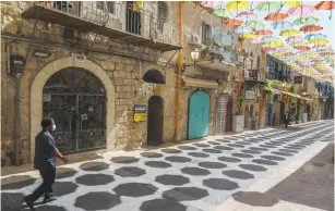  ?? ( Marc Israel Sellem/ The Jerusalem Post) ?? A MAN walks by closed shops in Jerusalem yesterday.