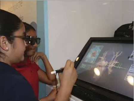  ?? PHOTO WILLIAM ROLLER ?? Valeria Ibarra (left) a fifth-grader, practices with the stylus of a zSpace 300 mixed reality computer system software in the mobile lab that visited De Anza Magnet School on Tuesday.