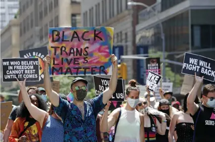  ?? Kathy Willens, The Associated Press ?? People hold signs as they participat­e in a queer liberation march for Black Lives Matter and against police brutality Sunday in Lower Manhattan in New York.
