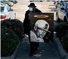  ?? THE WASHINGTON POST ?? Brett White, an artist from Dallas, carries a painting he made of George Floyd before lining up to attend the public viewing in Houston yesterday.