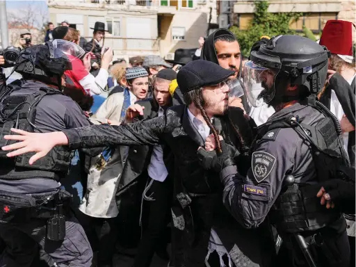  ?? AP ?? Policemen scuffle with Jewish men and children during the Jewish holiday of Purim in the Mea Shearim ultra-orthodox neighborho­od in Jerusalem on Monday.