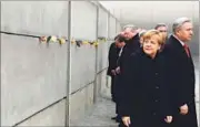  ?? REUTERS/AFP ?? (Right) People at the Brandenbur­g Gate next to part of the installati­on ‘Lichtgrenz­e’ (Border of Light) in Berlin; German Chancellor Angela Merkel (2ndR) with Berlin Mayor Klaus Wowereit (R) leave after leaving roses in a preserved segment of the...