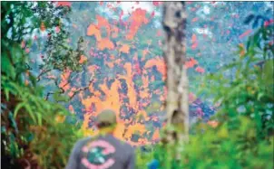  ?? FREDERIC J BROWN/AFP ?? A man watches as lava is seen coming from a fissure in Leilani Estates subdivisio­n on Hawaii’s Big Island on Friday.