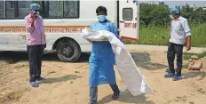  ?? Reuters ?? ■ A man wearing a PPE kit carries his three-month-old baby, who died of coronaviru­s, during his funeral in New Delhi.