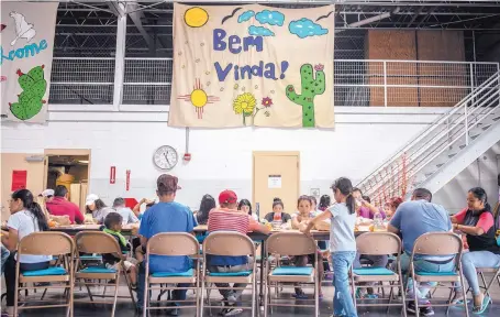  ?? ROBERTO E. ROSALES/JOURNAL ?? Migrants at the former National Guard armory in Deming have lunch in late July.