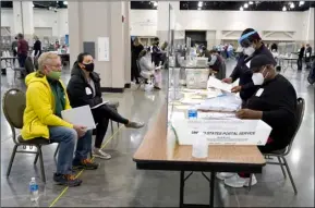  ?? AP PHOTO/NAM Y. HUH ?? Election workers, right, verify ballots as recount observers, left, watch during a Milwaukee hand recount of presidenti­al votes at the Wisconsin Center, Nov. 20, in Milwaukee.