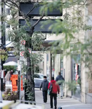  ?? ALLEN McINNIS ?? New electronic message boards installed on Sherbrooke St. W are obscured by a tree.