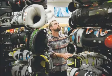  ?? Andy Cross, Denver Post file ?? A custom ski boot fitter looks through a large ski boot rack to find the right pair for a customer during the annual Powder Daze Labor Day ski sales at Christy Sports in Littleton in September 2015.