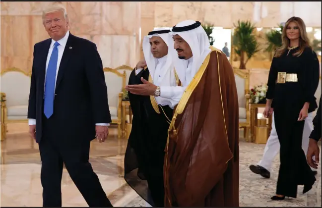  ?? Photograph: AP Photo/Evan Vucci ?? President Donald Trump walks with Saudi King Salman after a welcome ceremony at King Khalid Internatio­nal Airport in Riyadh yesterday