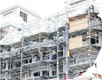  ?? BRUCE STOTESBURY, TIMES COLONIST ?? Constructi­on workers peel away some of the wrap from the Hotel Grand Pacific as the major renovation in Victoria’s Inner Harbour project nears completion.