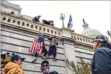  ?? JASON ANDREW / THE NEW YOK TIMES ?? Protesters backing then-president Donald Trump scale a wall of the U.S. Capitol on Jan. 6, the day a joint session of Congress was meeting to count the electoral votes and certify Joe Biden as the next president. A new report casts a harsh light on the Capitol Police for its preparedne­ss and response to the rioters.