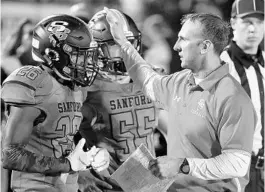  ?? STEPHEN M. DOWELL/ORLANDO SENTINEL ?? Seminole coach Don Stark, seen with a couple of his players during a 2019 game against Apopka, is leaving to take a head coaching position at a high school in Georgia.