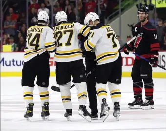  ?? AP ?? BIG LOSS: Hampus Lindholm is helped from the ice by Jake DeBrusk and Taylor Hall as Carolina’s Jordan Staal watches during the second period of Game 2 on Wednesday.