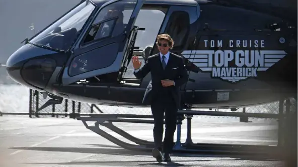  ?? AFP/VNA Photo ?? WINGMAN: Tom Cruise, arguably the world's biggest movie star, landed via helicopter onto a red carpet rolled across the USS Midway's sprawling top deck for the occasion.