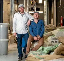  ?? PHOTO: ALDEN WILLIAMS/FAIRFAX NZ ?? Brothers in arms: Hummingbir­d Coffee’s Tim and Nick Cowper (sitting) with sacks of coffee beans.
