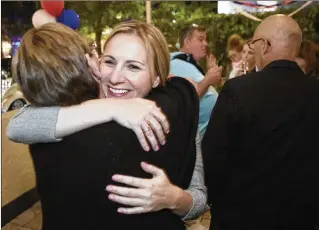  ?? DAMON HIGGINS / THE PALM BEACH POST ?? WINNER, District 1: Kelly Shoaf, a West Palm Beach City Commission candidate, hugs a supporter Tuesday at Hutton Seafood in the Northwood neighborho­od.