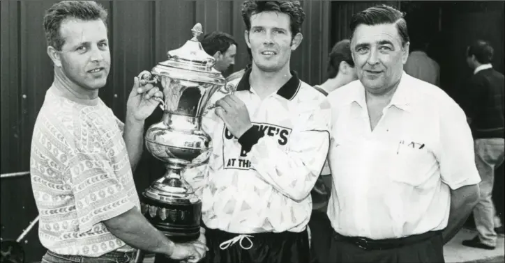  ??  ?? Brendan Kelly presents the Clancy Cup to Quay Celtic captain, Kenneth Cairns, with Patsy Bailey, Dundalk Junior League.