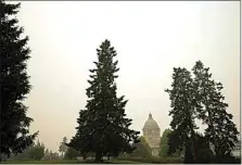  ?? TED S. WARREN / AP ?? The Washington state Capitol is shown under clear skies Wednesday, left, in Olympia, Wash., in contrast to several weeks earlier on Sept. 12, right, when the area was choked with smoke.