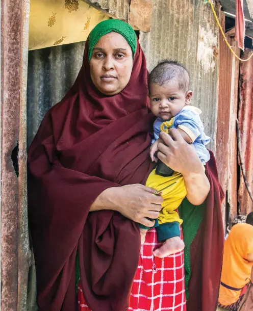  ?? Foto: Bettina Rühl ?? Farhiya Abdirahman Mohamed mit ihrem jüngsten Sohn vor ihrer Hütte in der somalische­n Hauptstadt Mogadischu