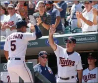  ?? The Associated Press ?? STRIKING POWER: Fans cheer as Twins manager Paul Molitor, right, high-fives Eduardo Escobar following Escobar’s two-run home run off Seattle starter Ariel Miranda in the first inning of Thursday’s game in Minneapoli­s.