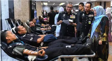  ??  ?? Mohamad Fuzi (third, right) with Dr Noryati during a blood donation drive in conjunctio­n with the 211th Police Day celebratio­n in Kuala Lumpur. — Bernama photo