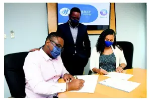  ?? ?? In this photo released on Wednesday, September 29, CEO and co-founder of Edufocal Gordon Swaby (left) and Assistant VicePresid­ent of Mayberry Investment­s Limited Rachel Kirlew sign the agreement for Mayberry to act as financial adviser for EduFocal. Mayberry Senior Vice-President of Investment Banking Dan Theoc looks on.