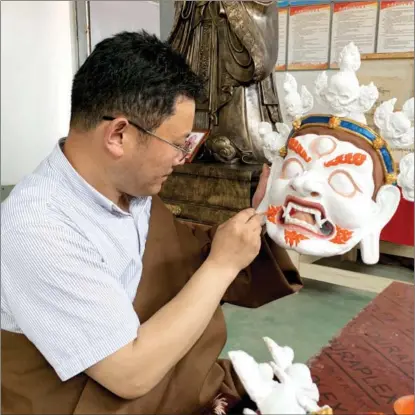  ?? ZHANG WENFANG / CHINA DAILY ?? An artist paints a Tibetan Opera mask at a business incubator park in Nangqen county, Yushu Tibetan autonomous prefecture, Qinghai province, on July 4.