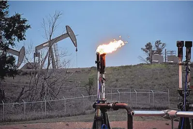  ?? MATTHEW BROWN/ASSOCIATED PRESS ?? A flare to burn methane from oil production is seen on a well pad near Watford City, N.D., in August 2021. The U.S. government this week is holding its first onshore oil and gas sales from public lands since President Joe Biden took office.