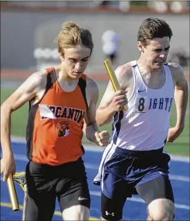  ?? PHOTOS BY MARC PENDLETON / STAFF ?? Arcanum junior Chance Klipstine (left) holds off Legacy Christian junior James Brads to win Tuesday’s 4x800 relay at Division III district meet in Dayton.