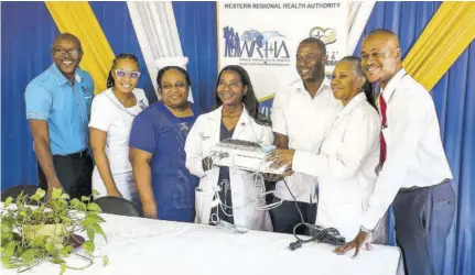  ?? ?? Vice-president of public health advocacy at Northwell Health in New York, Dr Sandra Lindsay (fourth left), presents a cardiotoco­graphy monitor to senior medical officer at Noel Holmes Hospital (NHH) Dr Patrice Monthrope. Sharing in the moment is her colleague, associate chief of labour and delivery at Northwell Health Dr Monique Defour Jones (second right). NHH team members looking on (from left) are its CEO Carlington Mclennon, registered midwife Arielle England-reid, acting director of nursing services Gracia Davis Brown and Parish Manager Aldwayne Beckford.