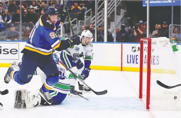  ?? DILIP VISHWANAT/GETTY IMAGES ?? Blues forward Vladimir Tarasenko sprawls over Canucks goalie Thatcher Demko after scoring to put St. Louis ahead 3-1 early in the second period.