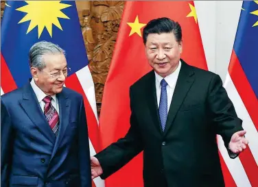  ?? WU ZHIYI / CHINA DAILY ?? President Xi Jinping greets Malaysian Prime Minister Mahathir Mohamad at the Great Hall of the People in Beijing on Monday. During his talks with Mahathir, Xi said the two countries should be dedicated to raising the representa­tion of developing countries in global affairs.