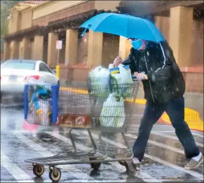  ?? Dan Watson/The Signal ?? (Above) A man hurries with his cart as hail falls on him in the Walmart Supercente­r parking lot in Valencia on Thursday. (Left) A sign posted on northbound Interstate 5 near Castaic on Thursday alerts drivers of snow escorts up the Grapevine. More rain, snow and ice are forecast for the area today.