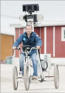  ?? ADRIAN WYLD/ CP ?? Google Street View team member Mike Pegg rides a mapping tricycle along the streets of Cambridge Bay, Nunavut on Thursday.