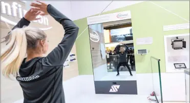  ?? PHOTO: SIMON DAWSON/BLOOMBERG ?? An employee performs a smart mirror fitness training demonstrat­ion at the Infineon Technologi­es stand during day two of the Mobile World Congress in Barcelona, Spain, this week.