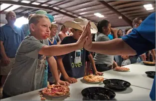  ?? Morgan Timms ?? A contestant is high-fived after a pie eating contest Sunday (Aug. 26) at the Taos County Fair.