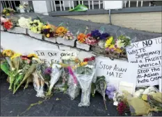  ?? CHOI
AP PHOTO/CANDICE ?? Flowers, candles and signs are displayed at a makeshift memorial on Friday in Atlanta. Robert Aaron Long, a white man, is accused of killing several people, most of whom were of Asian descent, at massage parlors in the Atlanta area.